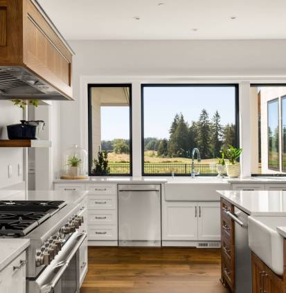 Kitchen Detail in New Luxury Home: White Counters, Gas Range, Two Farmhouse Sinks, and Beautiful Window Views