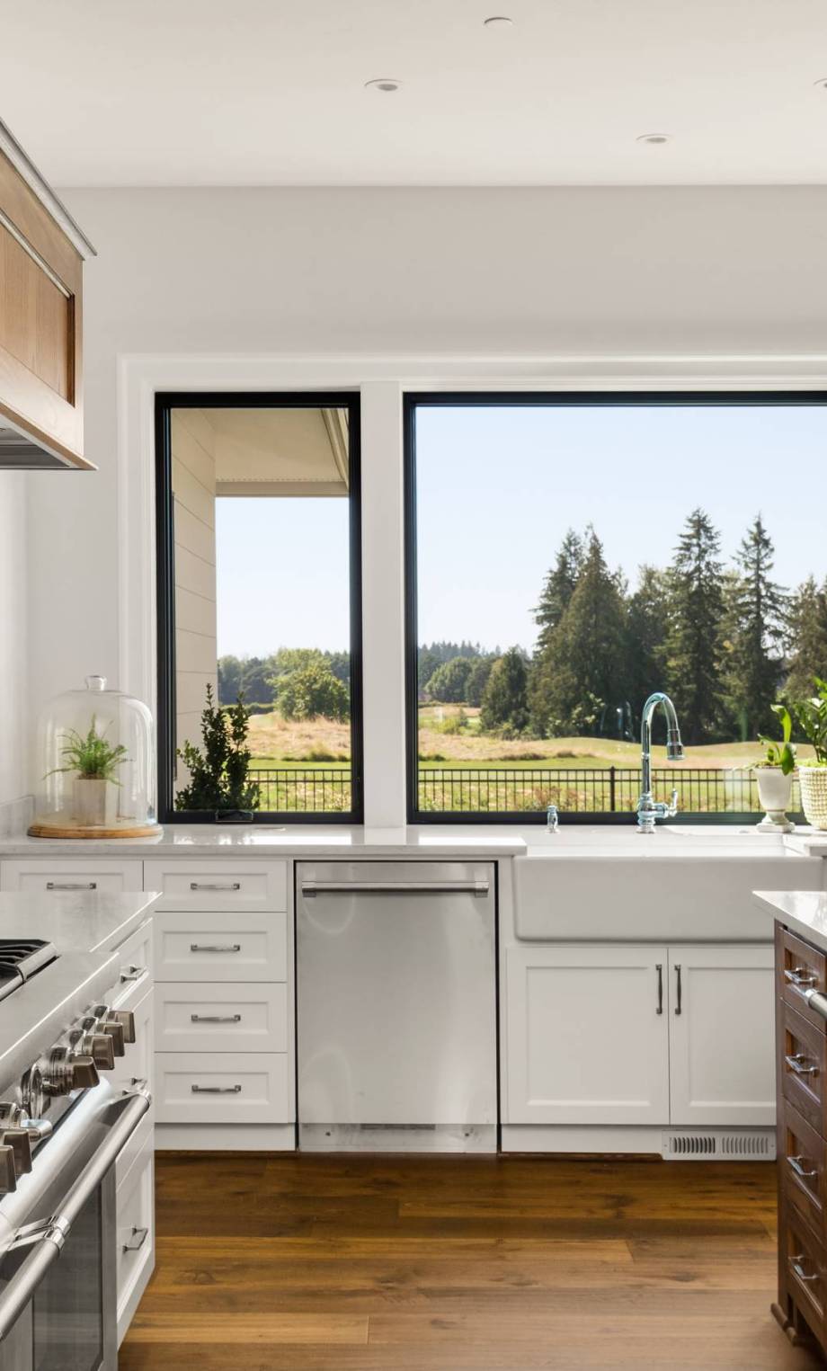 Kitchen Detail in New Luxury Home: White Counters, Gas Range, Two Farmhouse Sinks, and Beautiful Window Views